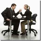 Man and woman arm wrestling on table.